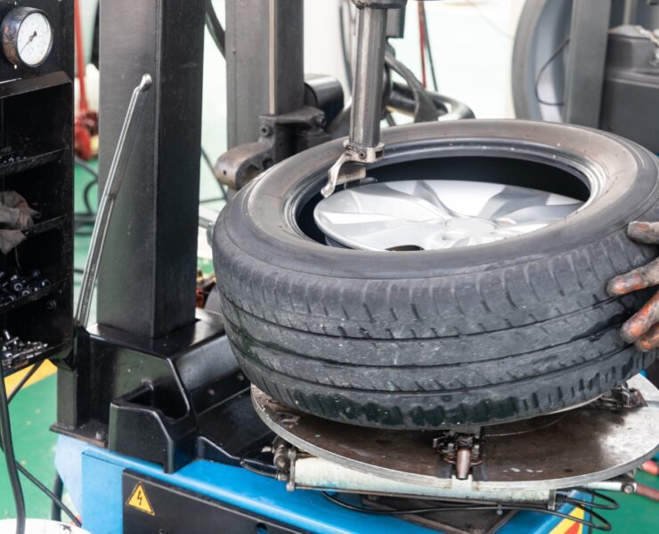 Series of worker removing tire from rim with tire removal machinery equipment